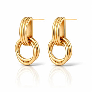 A pair of gold-toned hoop earrings with a multi-band top and interlocking circular drop, shown on a clean white background with a soft reflection below.