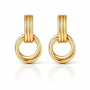 A pair of gold hoop earrings with three parallel vertical bars at the top and two interlocking curved hoops below, shown on a clean white background with a soft reflection underneath.