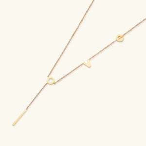 Gold necklace with letter pendants on a white background