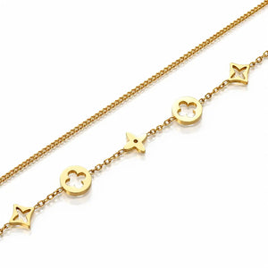 A gold chain bracelet featuring openwork monogram-style charms, including a four-leaf clover, a star, and a trefoil, displayed on a clean white background.