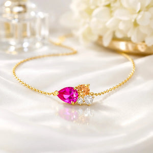 Gold bracelet with pink gemstone on a white surface