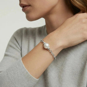 Woman wearing a rhodium-plated silver chain bracelet with a large white pearl accent