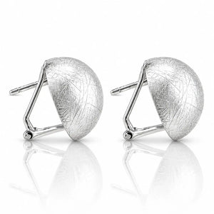 A pair of silver geometric stud earrings with a textured, crackled finish on a reflective white surface.