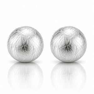 A pair of silver spherical earrings with a textured, fibrous outer layer, displayed on a reflective white surface against a white background.