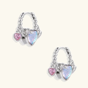 Heart-shaped earrings with pink and blue gemstones on a white background
