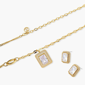 Gold necklace and earrings set with rectangular clear gemstones and pavé accents on white background