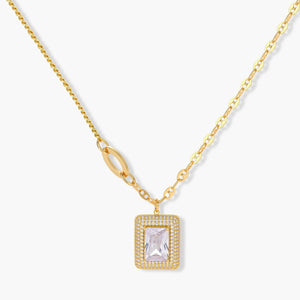 Gold chain necklace with rectangular halo pendant and clear gemstone on white background