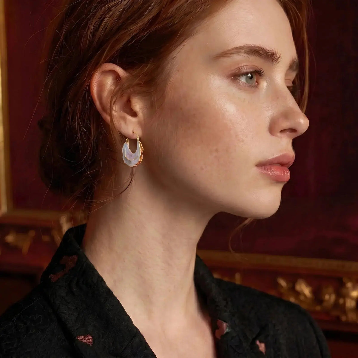 Close-up of a woman wearing earrings with a red background