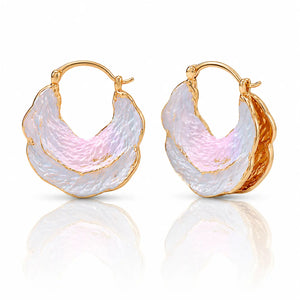 Gold hoop earrings with pink and white stone inlay on a reflective surface