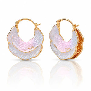 Gold hoop earrings with pink and white stone inlay on a reflective surface