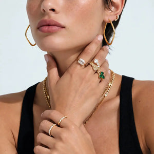 Woman wearing 18K gold geometric hoop earrings with elegant gold jewelry