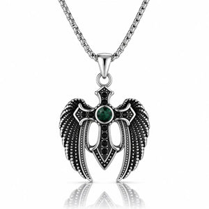 A silver-toned angel wing pendant necklace with a central green gemstone and black accents, suspended from a silver chain on a white background with a reflection below.