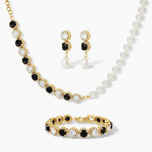 Gold jewelry set with black and clear gemstones, pearl necklace, and drop earrings.