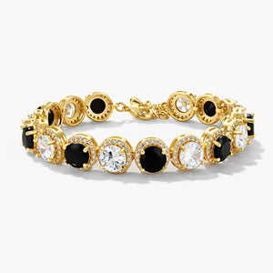 Gold tennis bracelet with alternating black and clear round stones, pavé halo setting on white background