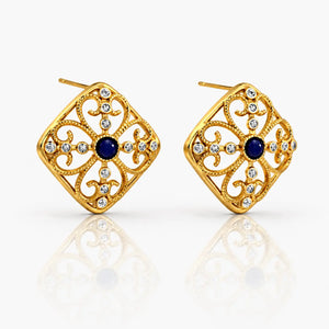 Gold earrings with blue gemstones on a white background