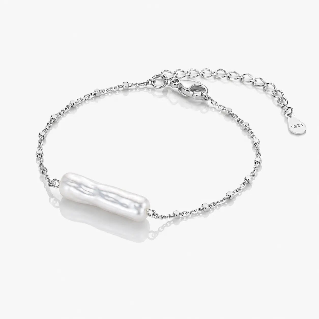 Silver bracelet with a pearl-like charm on a white background
