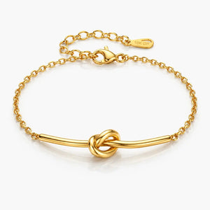 Gold bracelet with a knot design on a white background