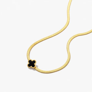 18K gold necklace with black clover pendant on white background