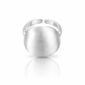 A silver-toned adjustable ring with a large, rounded, brushed-metal face, shown on a clean white background with a soft reflection below.