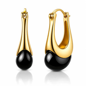 A pair of gold and black drop hoop earrings on a clean white background. Each earring features a polished gold huggie hoop and a sleek, curved gold stem that transitions into a smooth, glossy black teardrop bead.