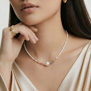 Close-up of a woman wearing a pearl necklace with gold accents.