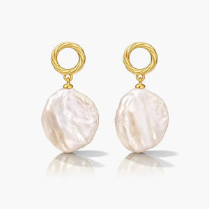 Pair of gold vermeil earrings with textured hoop and large baroque pearl drops on white background