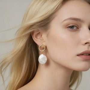 Woman wearing 18K gold vermeil drop earring with large baroque pearl accent