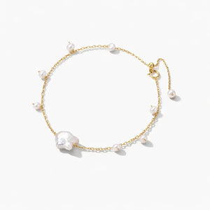 Delicate gold chain bracelet with white freshwater pearls on a white background