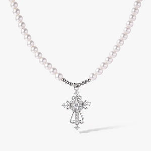 White gold cross pendant on pearl necklace, elegant jewelry on white background
