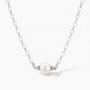 Silver chain necklace with single round pearl and small diamond accents on white background