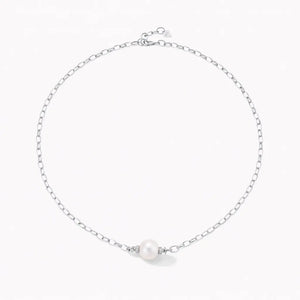 Silver chain necklace with single round pearl centerpiece on white background