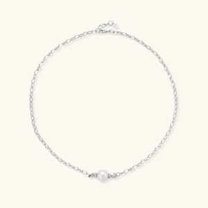 Silver chain necklace with a single pearl on a white background