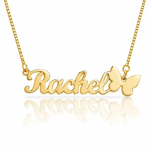 A gold nameplate necklace spelling 'Rachel' with a butterfly charm at the end, shown on a white background with a soft reflection below.