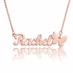 Rose gold personalized name necklace with the name 'Rachel' in cursive script and a butterfly charm, shown on a white background with a reflection below.
