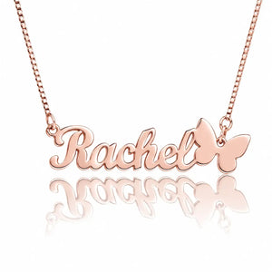 Rose gold personalized name necklace with the name 'Rachel' in cursive script and a butterfly charm, shown on a white background with a reflection below.