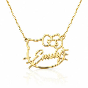 A gold necklace featuring a custom name pendant in the shape of a cartoon cat face with a bow, with the name 'Emily' written in cursive script, shown on a white background with a soft reflection.