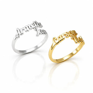 Two personalized name rings on a white reflective background. One ring is silver-toned with the script names 'Armetta' and 'Jazzy'.