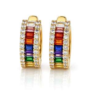 A pair of gold huggie hoop earrings featuring a vibrant rainbow channel set with baguette-cut gemstones and rows of clear round stones, shown on a reflective white background.