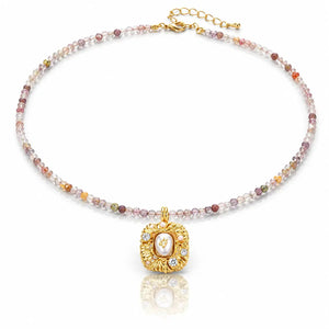 Necklace with multicolored beads and a gold pendant on a white background