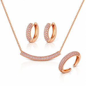 Rose gold jewelry set featuring a necklace with a pavé curved bar pendant, matching pavé hoop earrings, and a pavé open cuff ring, displayed on a clean white background.