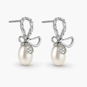 Pearl earrings with bow design on a white background