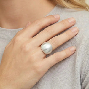 Hand wearing a bold dome-shaped 925 silver ring on index finger, light sweater background