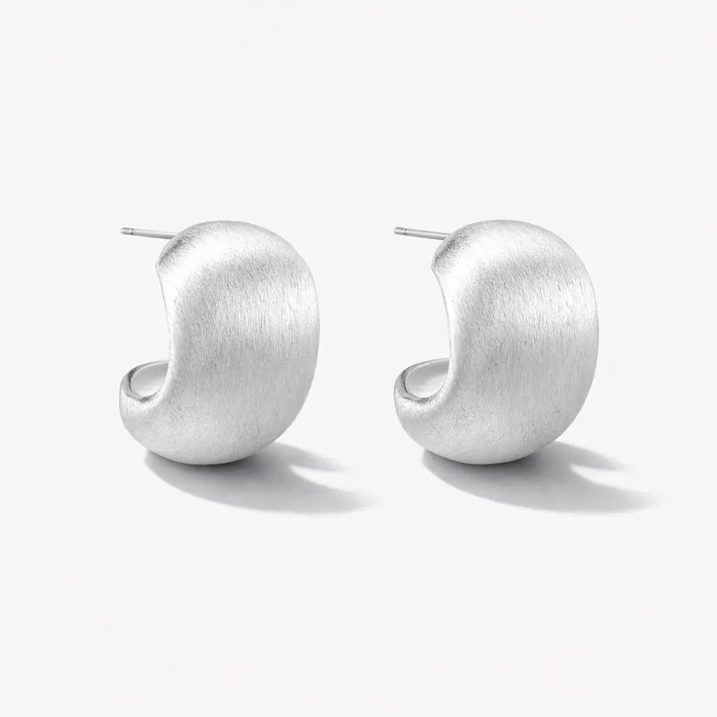 Pair of curved brushed silver stud earrings on a white background