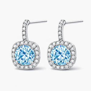 Silver earrings with round blue gemstones and halo of clear crystals on white background