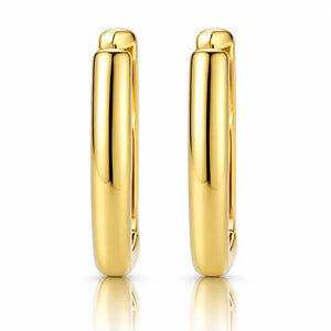 A pair of polished yellow gold hoop earrings shown from the side against a clean white background with a subtle reflection below.