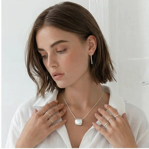 Woman wearing a necklace with a white background