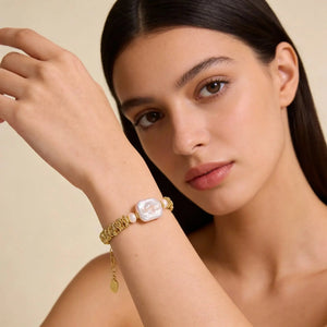 Woman wearing 18K gold plated bracelet with baroque pearl and textured gold chain
