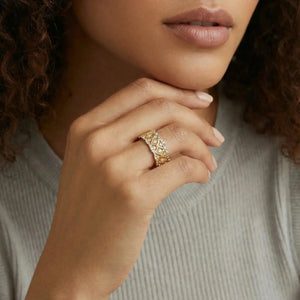 Woman wearing 18K gold geometric lattice ring with zirconia stones on her finger