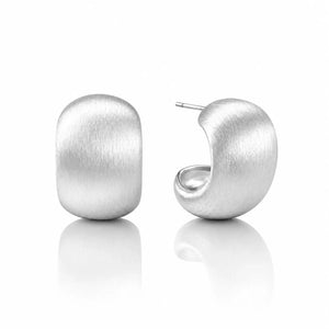 A pair of matte silver huggie hoop earrings, one shown from the front and the other from the side with a post visible, set against a clean white background with a soft reflection below.
