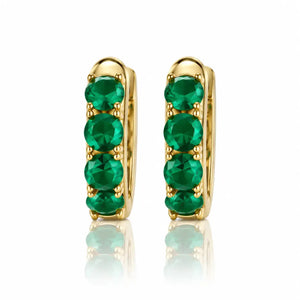 Gold hoop earrings with green gemstones on a white background